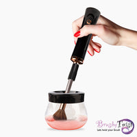 Thumbnail for Elektrisches Pinselreinigungsgerät mit Behälter, rosa Flüssigkeit und Hand mit rotem Nagellack