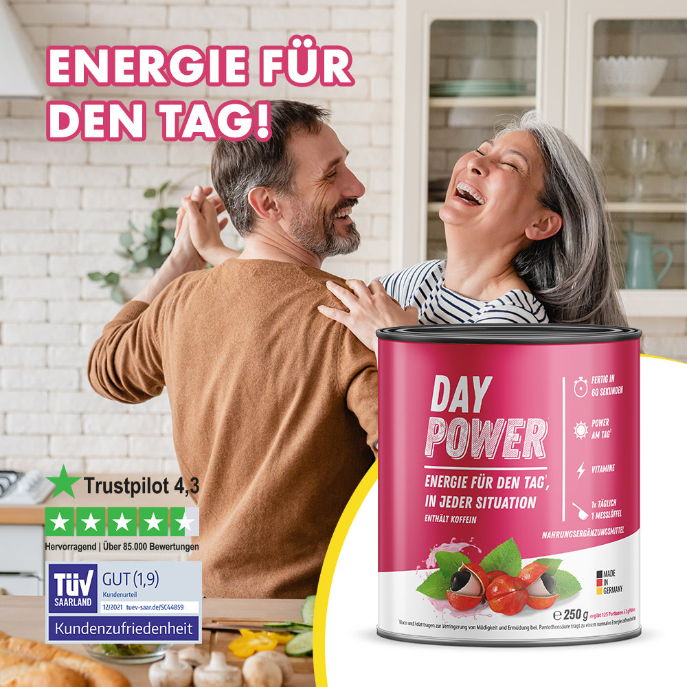 Paar tanzt in Küche mit Dose Day Power Nahrungsergänzung und Bewertungssiegeln im Vordergrund