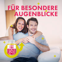 Thumbnail for Lady Fire Dose mit 60 Kapseln neben lächelndem Paar auf Sofa und großem pinkem Text oben sichtbar